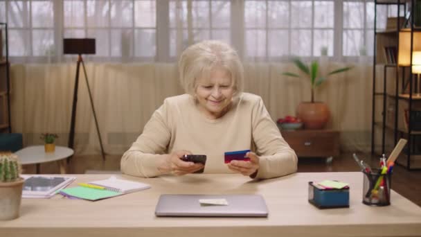 Mutlu Yaşlı Kadın Internet Üzerinden Kredi Kartıyla Evdeki Oturma Odasında — Stok video