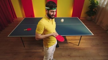 Çekici adam pinpon oyuncusu çok profesyonel raketle topa vuruyor sonra kameraya bakıp komik bir yüz ifadesi takınıyor ve masa tenisi oyununu başlatmaya hazırlanıyor. ARRI Alexa Mini 'de çekilen