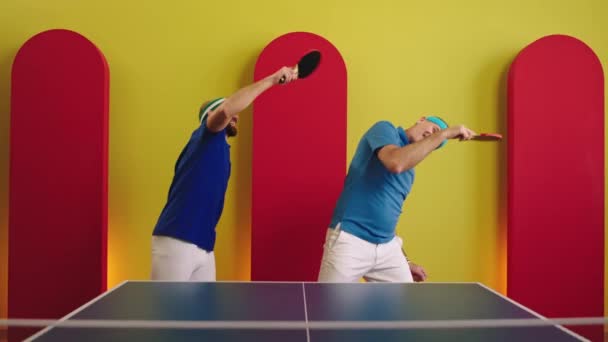 在乒乓球比赛开始前 为了健康的生活方式 老男人和他的儿子兴奋地跳起舞来 大大的笑着 他们手里拿着桨 向Arri Alexa Mini开枪 — 图库视频影像
