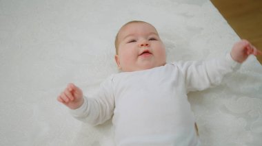 Kameranın önünde karizmatik güzel bebek yatağa uzanıyor ve annesinin çocukluk ve annelik kavramına karşı koymaya çalışıyor. Portre