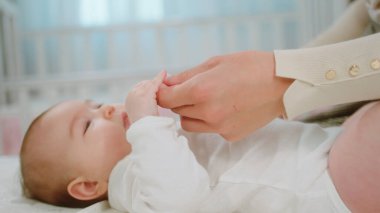 Kameranın önünde güzel bir bebek annesiyle el ele tutuşurken ve yatağa uzanırken mutlu hissediyor..