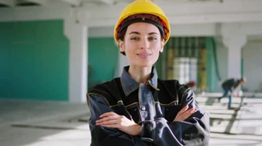Şantiyedeki inanılmaz kadın mühendis kameranın önünde güzel poz veriyor güzel bir gülümsemesi ve güvenlik kaskı ve ekipmanı var. ARRI Alexa Mini 'de çekilen.