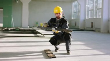 İnşaatta büyük bir uzay binası. Konsantre inşaat işçisi. İnşaat malzemeleri kullanıyor ve koruyucu ekipman kullanıyor. ARRI Alexa Mini 'de çekilen.