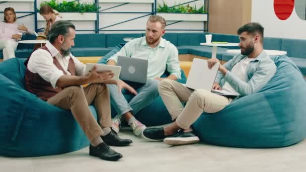 Drei Sehr Ernst Aussehende Geschäftsleute Mit Bärten Sitzen Blauen Bohnensackstühlen — Stockvideo