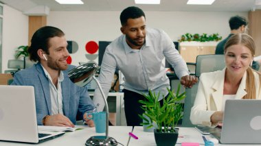 Beyaz, yakışıklı bir adam ve takım elbiseli güzel bir kadın ofiste çalışırken kendi aralarında konuşuyorlardı. Arka planda siyah bir kadın koltuğunda ve şurada konuşuyordu.