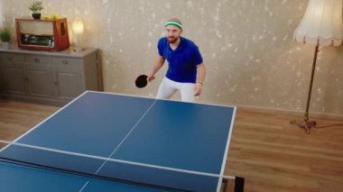 Yüksek karizmatik ve çekici bir adamın pinpon oynarken videosunu çekip topa vuruyor..