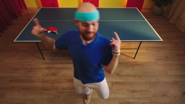 快乐的白人小伙子在乒乓球比赛中获胜后 有很多精力跳舞 动作也很滑稽 他笑得很开心 — 图库视频影像
