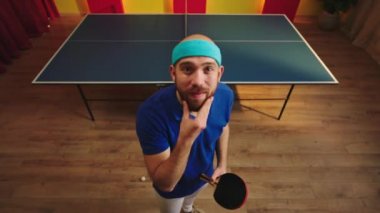 Kameranın önündeki çok enerjik masa tenisi oyuncusu topunu alır ve kameranın önünde topa vurmak için kürek çekmeye başlar. 4k