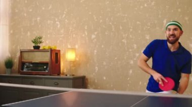 Ping atan yakışıklı bir adam kameranın önünde raketle topları yakalıyor ve heyecanlanıyor ve gülümsüyor. ARRI Alexa Mini 'de çekilen