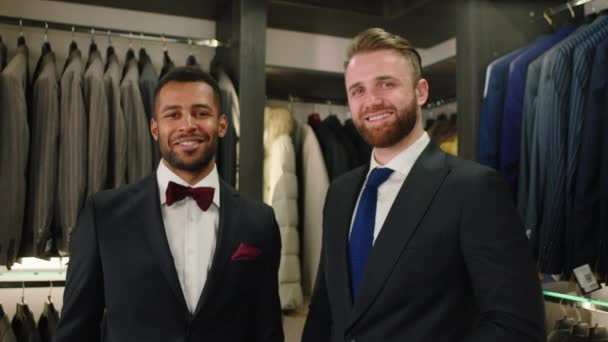 Hombres Multiétnicos Guapos Una Tienda Trajes Sonriendo Grande Mirando Directamente — Vídeos de Stock