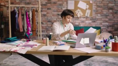 Fashion design woman very creative make some new design of clothes on her paper then using the laptop to work online on her inspiration board concept of small business atelier design fashion. 4k