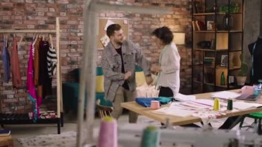 Terzi ofisindeki iki kişi dans ediyor ve birbirleriyle eğlenirken kafalarını sallıyorlar ve çok mutlu görünüyorlar. 4k