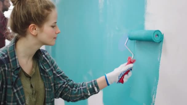 Jovem Atraente Pintando Uma Cor Azul Paredes Casa Usando Rolo — Vídeo de Stock