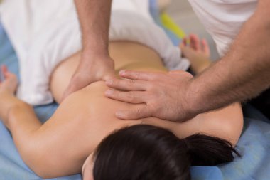 Massage room the therapist doing back massage for muscle relaxation the client woman laying down on the massage table and enjoy the spa time.
