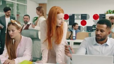 Ofisteki üç meslektaşın hareketli bir görüntüsü dizüstü bilgisayarlarına bakıyor ve birbirlerine iş hakkında tavsiyelerde bulunurken, diğer üç işçi de kendi aralarında konuşuyor. 4k