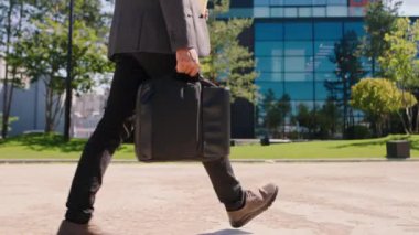 Walking down on the street in modern business centre park details man holding a bag and going to his work. 4k