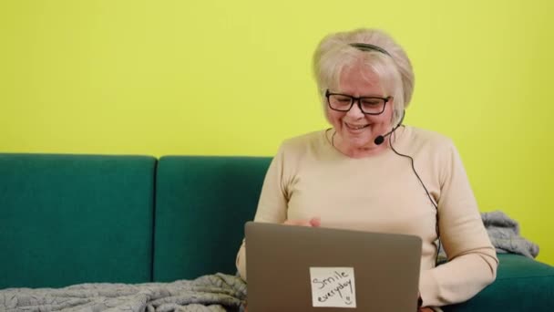 Dizüstü Bilgisayarı Dava Eden Mutlu Yaşlı Kadın Kulaklığı Taktığı Koltukta — Stok video