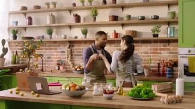 Attractive man and his girlfriend very beautiful enjoy the time together at the kitchen while cooking the dinner together they dancing together. 4k