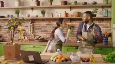 Multiethnic couple young and good looking have a good morning together singing and dancing at the kitchen while preparing the breakfast together before go to work. Shot on ARRI Alexa Mini