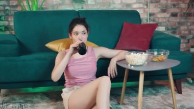 Attractive young woman support fan looking at the tv match in the living room she gesticulating with hands getting excited. Shot on ARRI Alexa Mini