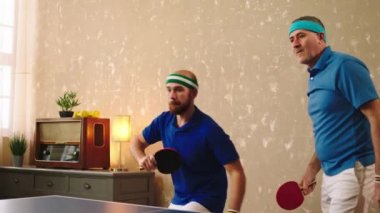 Good looking old man and his son playing together like a team the table tennis they hugging each other after they win the game they catch the balls. 4k