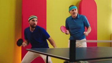 Concept of healthy lifestyle and sport two charismatic men playing the ping ping or table tennis they win the game getting excited catch the balls with the racket. 4k