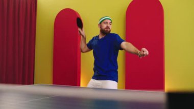 All equipment guy in front of the camera before start to play on the ping pong dancing charismatic and smiling large he is feeling excited before game holding his paddles. 4k