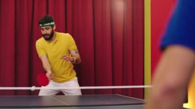 In front of the camera charismatic man playing with his friend the ping pong game he get excited to win on the game he catch the ball and hitting great with the racket. Shot on ARRI Alexa Mini