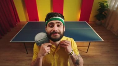 Kameranın önünde karizmatik masa tenisi oyuncusu hazır olun. Masa tenisi oynamaya başlayın. Üniformasını giyiyor ve en sevdiği raketini tutuyor. ARRI Alexa Mini 'de çekilen