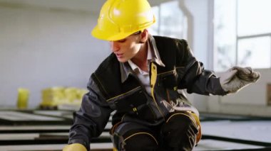 Dancing happy and excited woman constructor worker at construction site using the brush to painting the building materials she wearing safety helmet and special uniform. 4k