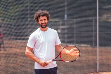Tenis oyuncu adam portresi. Önden görünüm. Kameraya bakıyor. sahada.