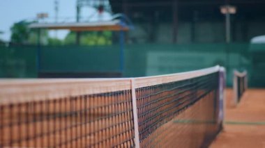 Açık tenis kortunda iki bayan oyuncu oyuna başlamadan önce tenis ağının üzerinden el sıkışıyor. 4k