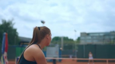 Closeup to the camera professional woman playing the tennis on the tennis court outside concept of sport healthy lifestyle.