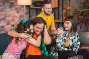 Bir spor maçı izlemek için bir araya gelen karizmatik genç arkadaş grubuna yakın takım kazandığında heyecanlanıp çığlık atıyorlar..