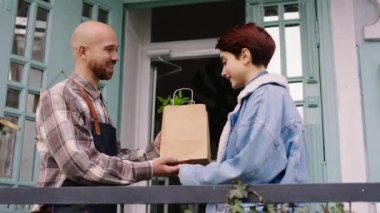 Çiçekçide kameranın önünde çiçekçi adam ve girişimci eko poşetteki müşteriye çiçekleri verirken en sondaki adama güle güle diyen büyük bir şey hakkında konuşuyorlar.