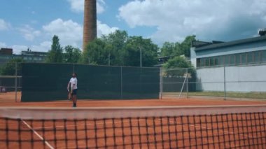 Handsome man tennis player hitting the tennis ball with the racket outdoor on the tennis court concept of healthy lifestyle and professional sport. Shot on ARRI Alexa Mini