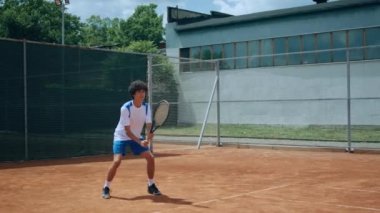 Professional tennis match young guy hitting the ball the sitting on the knees and getting very excited after he win the match outdoor on the clay court. 4k