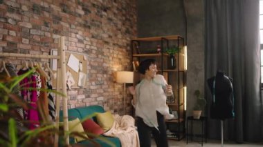 Loft tailoring atelier crazy dressmaker dancing and get excited at her workplace she take the measure and start to measurement the dress. Shot on ARRI Alexa Mini