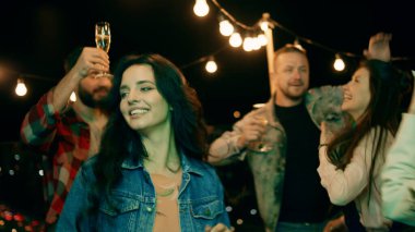 Attractive and charismatic group of friends have a big party time on the rooftop of terrace they dancing and enjoy the time together.