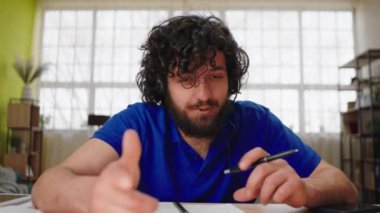 At home in living room in front of the camera call centre worker man discussing excited with some client he explains something he wear the headset. 4k