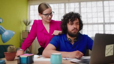 In the office centre supervisor female very beautiful giving some help to her office worker man they discussing together and analysing the problem.