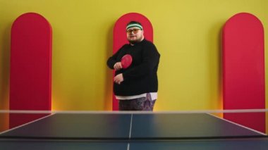 Good looking fat man in front of the camera posing and crossing hands before start to play on the table tennis he smiling charismatic and wearing sunglasses. Shot on ARRI Alexa Mini