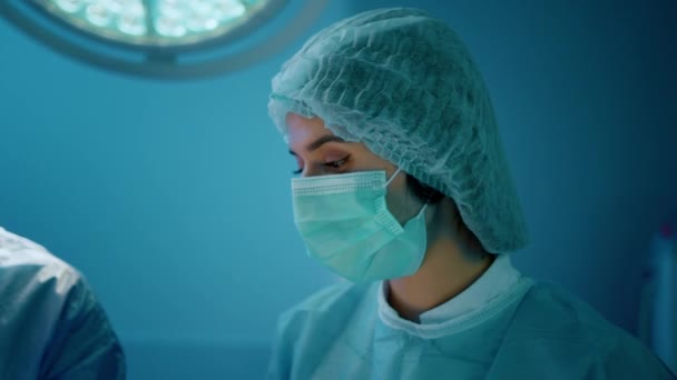Μια Γυναίκα Μάσκα Γιατρού Και Δίχτυ Για Μαλλιά Είναι Χειρουργείο — Αρχείο Βίντεο