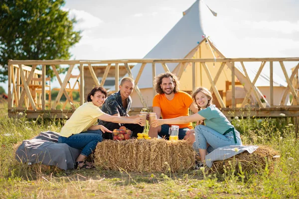 travel, tourism, hike, picnic and people concept - group of happy friends with tent and drinks.