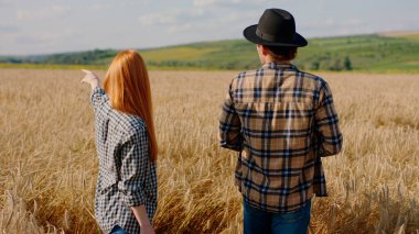 Farming industry concept one beautiful couple have a great day in the middle of wheat field they analysing the harvest of this year and discussing together. Portrait