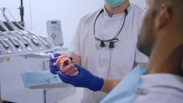 Пацієнт Сидить Стоматологічному Стільці Розмовляє Лікарем Стоматологом Захисною Маскою Пояснює — стокове відео
