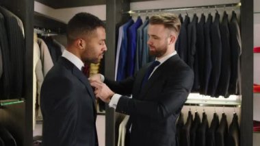 Great looking businessman try a new black suit from the new collection the consultant man try to wear right on his client the suit. 4k