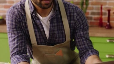 Great looking man at home at the kitchen island in the morning he use the credit card to make a payment form the laptop. 4k