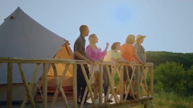Bir grup güzel insan doğanın tadını çıkaran bir balkonlu bir çadırda birlikte vakit geçiriyorlar. 4k