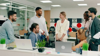 Kararlı bir iş adamı parlak bir ofis odasına girer ve toplantıdaki insanları tokalaşarak selamlar..